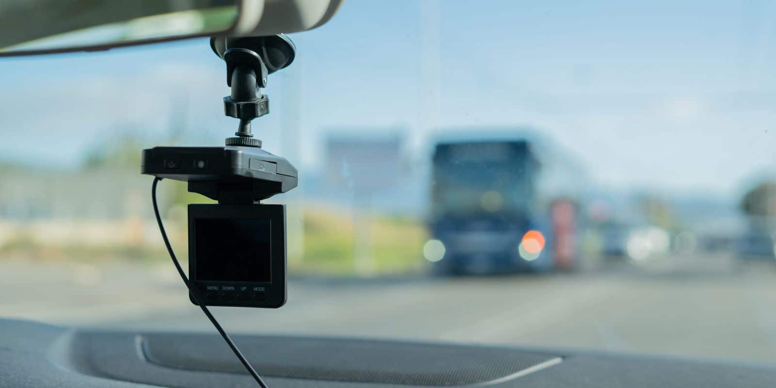 A car camera is mounted on the dashboard of a vehicle.